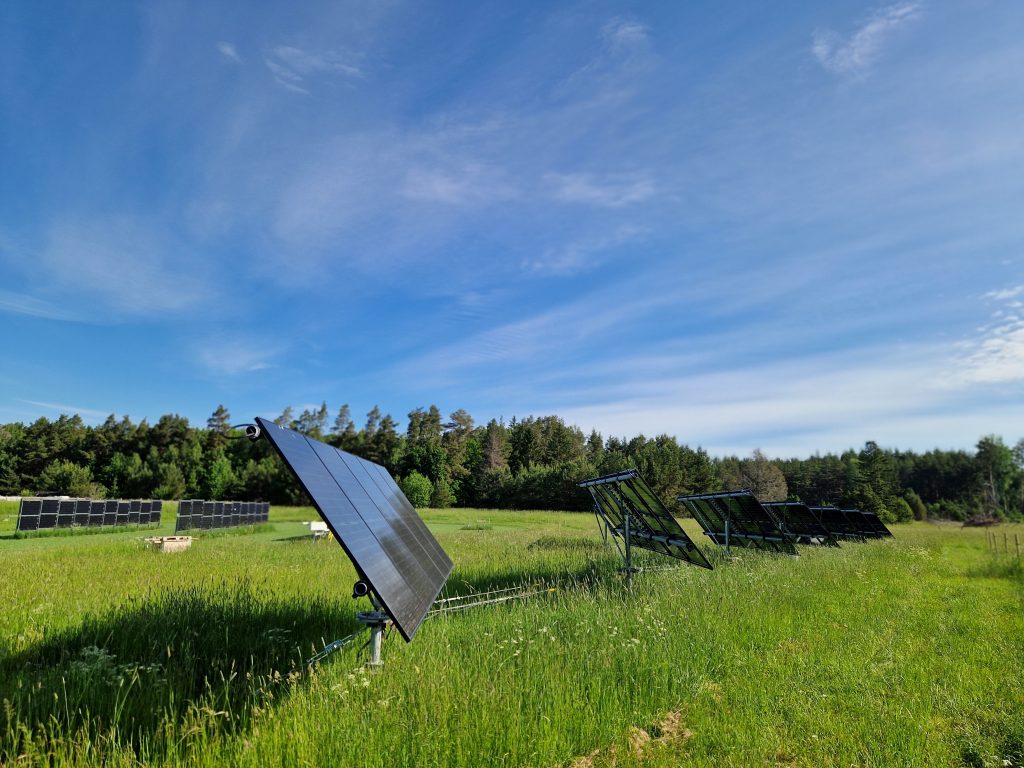 Solceller på en stor grön äng.