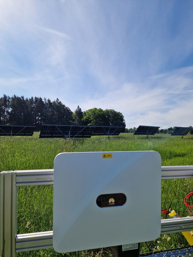 Solcellsmekaniker med solceller i bakgrunden.
